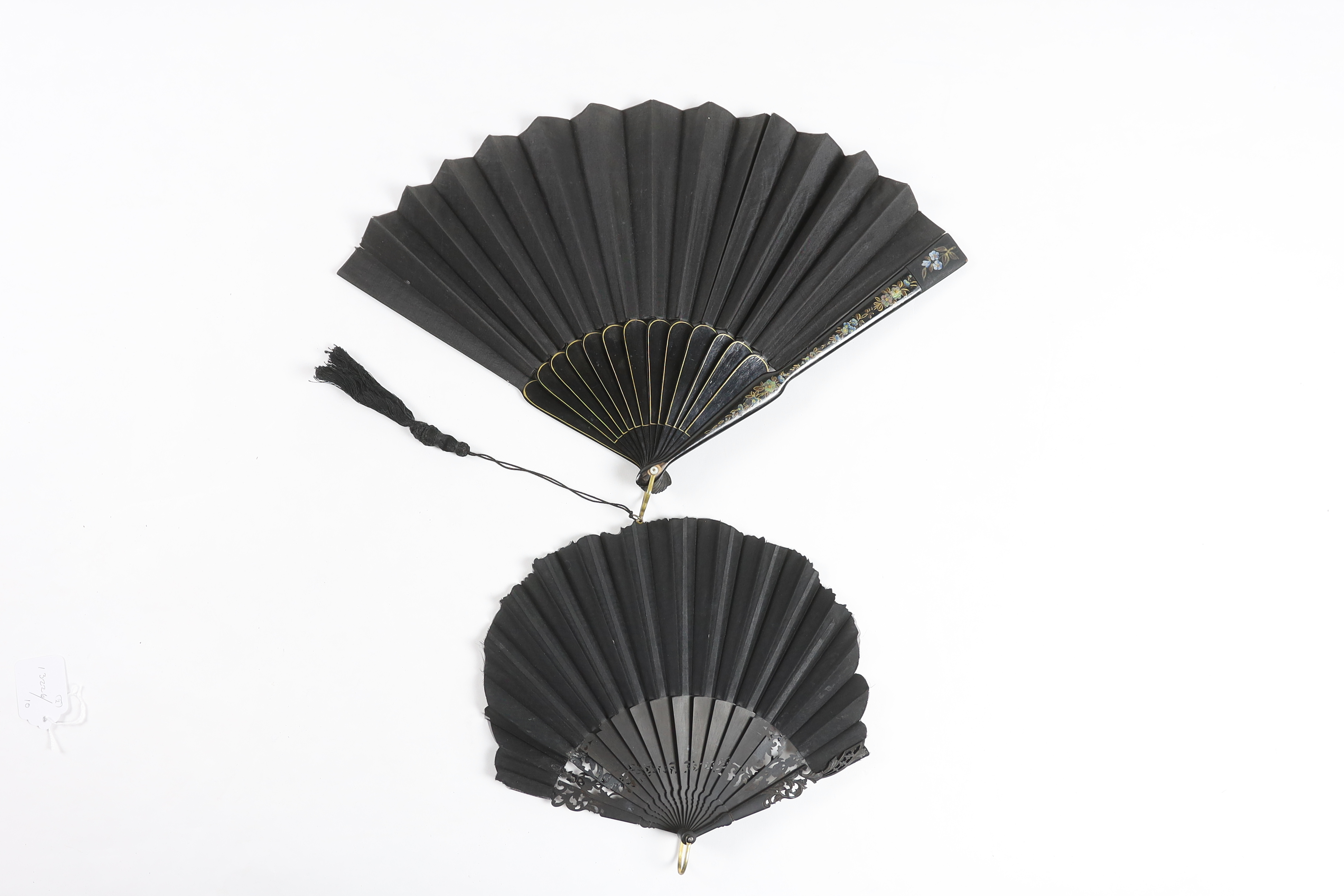 A late 19th century hand painted shaped and carved figurative fan, signed, together with a lacquer and mother of pearl fan, with matching leaf and guard decoration